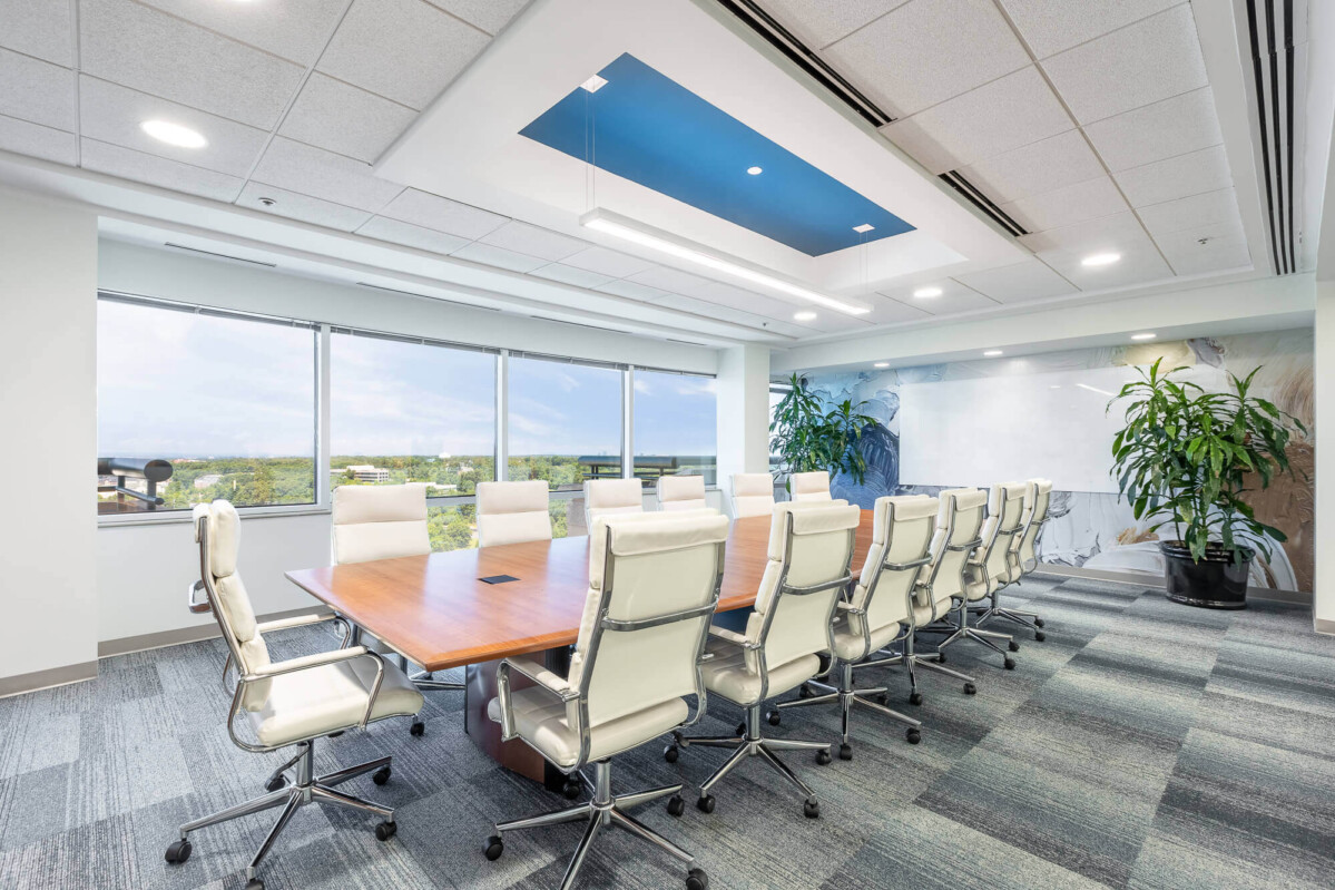 ?seraph accel gi=wp content%2Fuploads%2F2024%2F07%2F008 LC - Metro Offices A modern conference room with a long wooden table, surrounded by white office chairs, large windows providing natural light, and a ceiling with a blue accent.