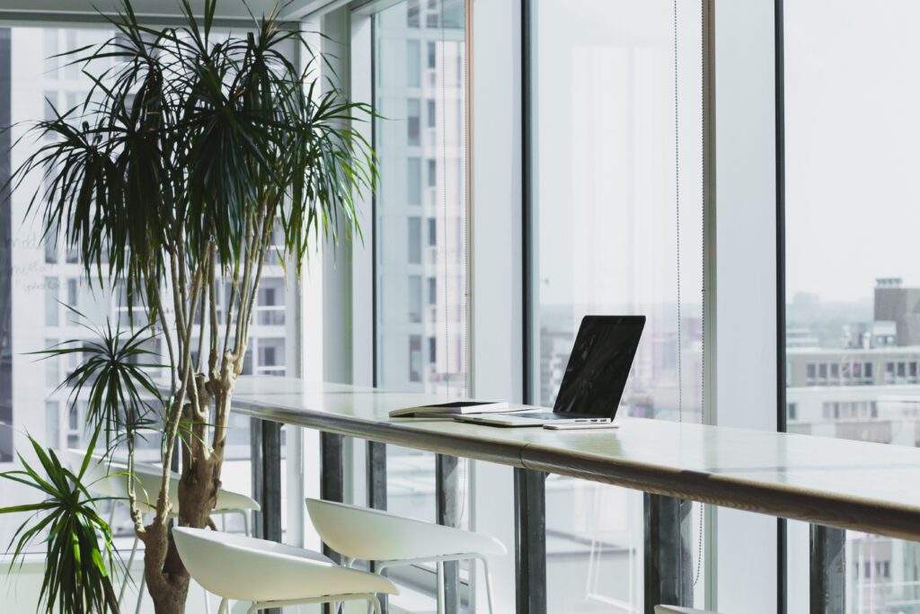 alesia kaz VWcPlbHglYc unsplash - Metro Offices A coworking space with a white desk and a laptop on it.