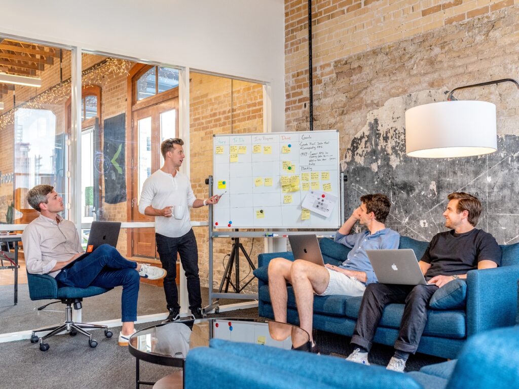austin distel wD1LRb9OeEo unsplash - Metro Offices In a coworking space, a group of people sits around a table in an office.