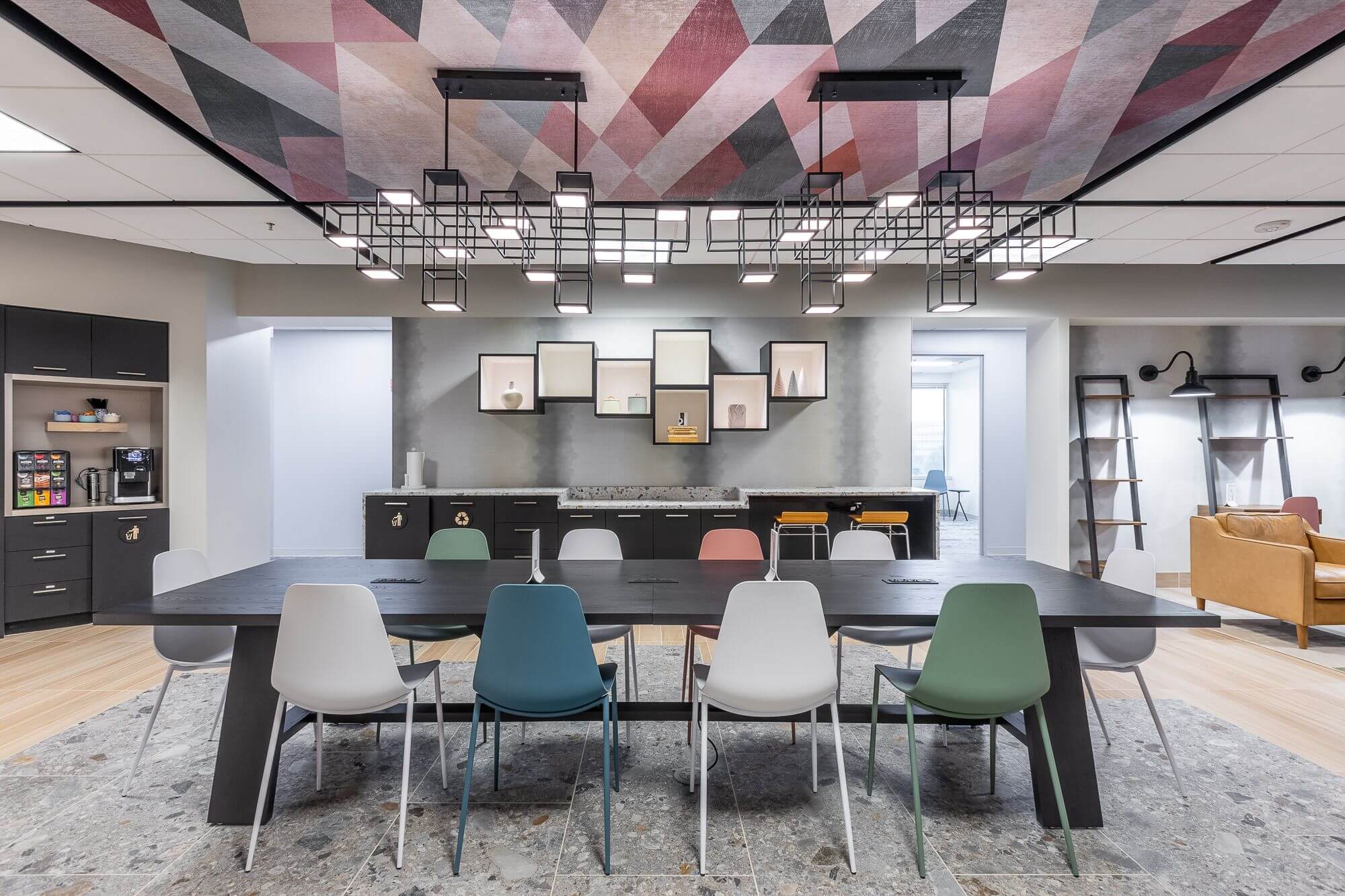 LOUNGE6 - Metro Offices A vibrant coworking space furnished with a table and chairs, featuring a colorful ceiling design.