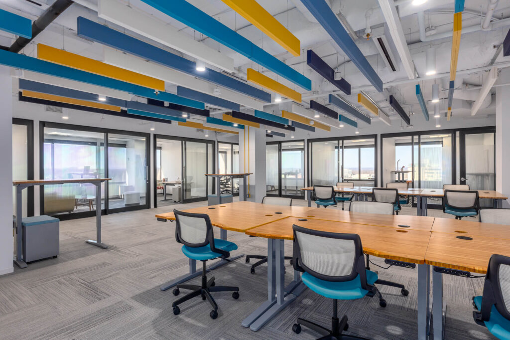 MetroOffices Tysons 23 - Metro Offices An open coworking space with colorful ceilings and desks.