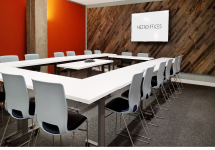 large table - Metro Offices A meeting room with chairs and a large screen.