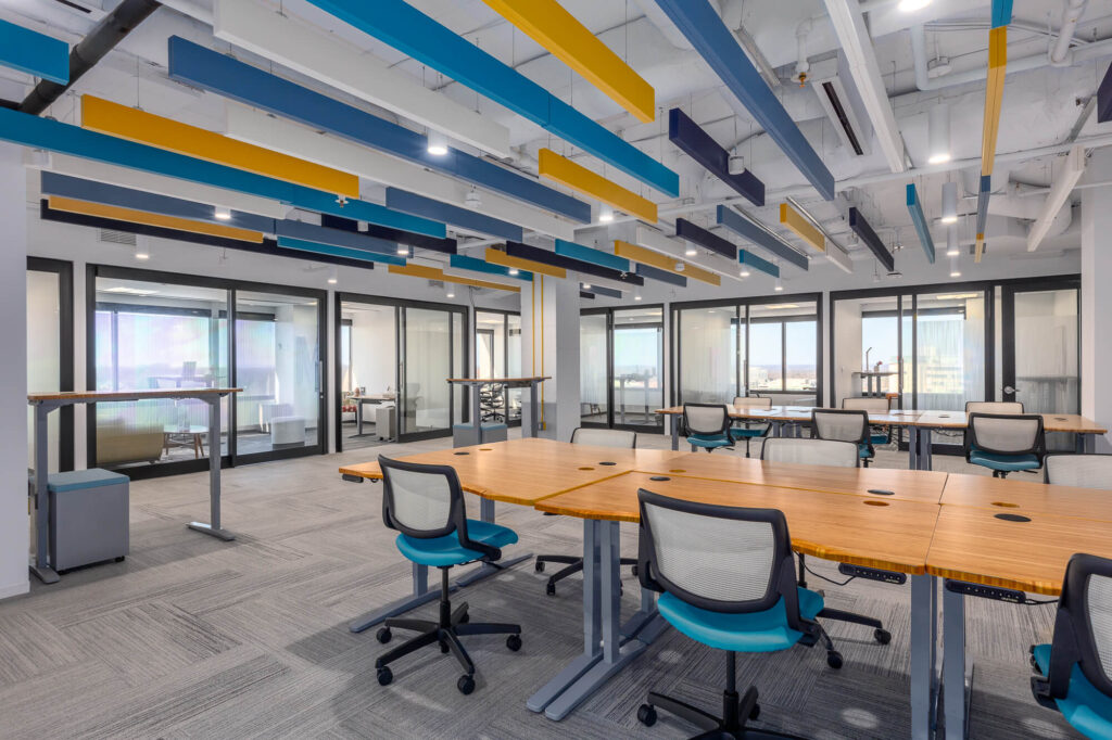 An open coworking space with colorful ceilings and desks.
