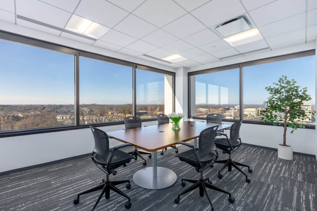 A conference room with large windows overlooking a city, perfect for meetings and presentations.