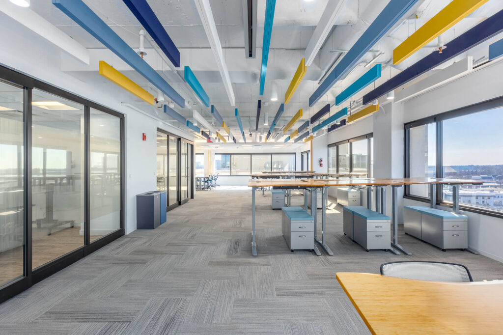 A vibrant coworking space with colorful ceilings and desks.