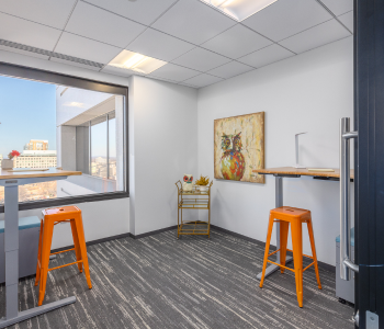 An office suite with orange stools and a view of the city.