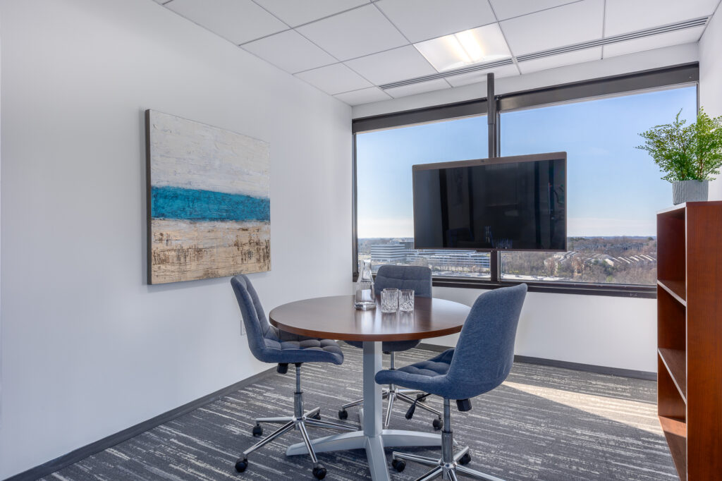 A virtual office with a table and chairs and a view of the city.