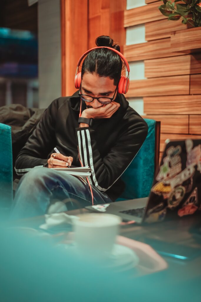 A man enjoying music while working in a shared workspace.