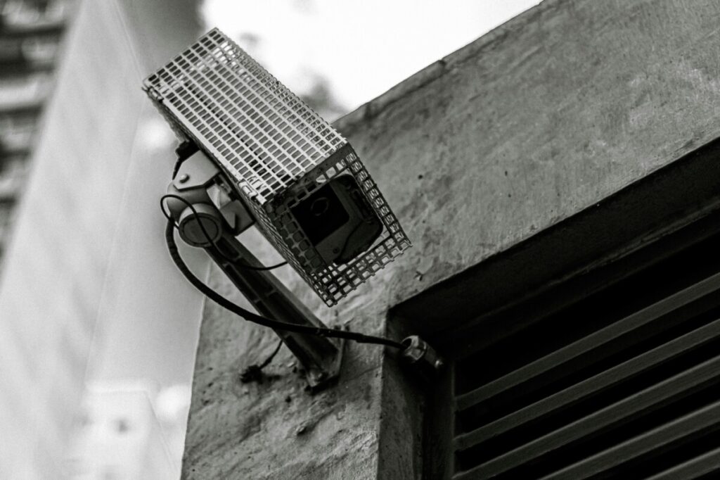 A security camera positioned on the exterior wall of a workspace building.