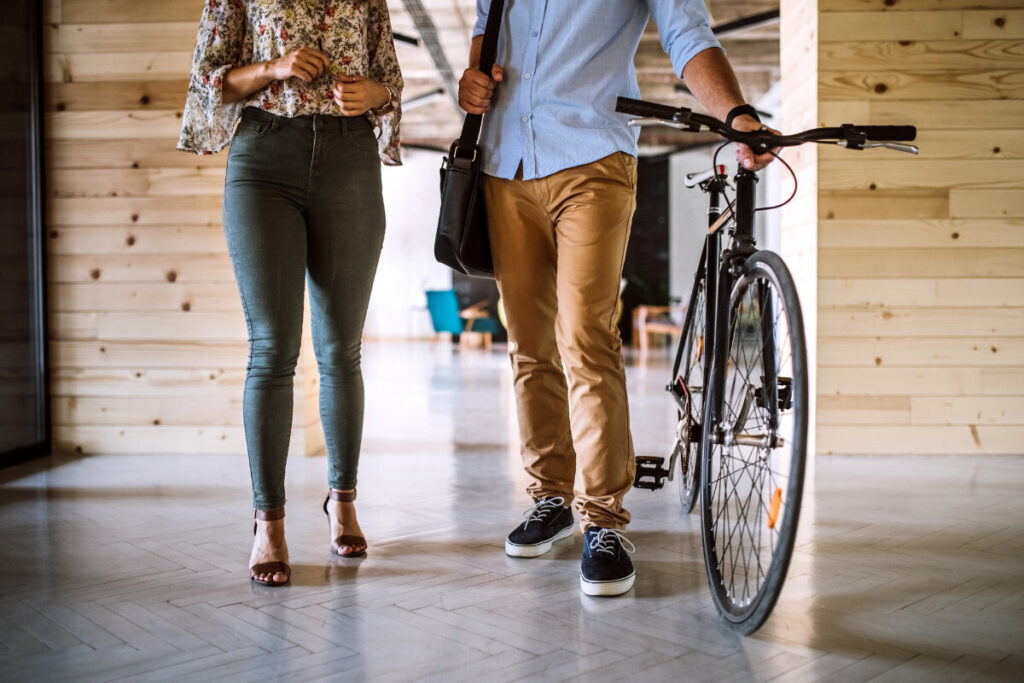 A man and woman standing next to a bicycle in an eco-friendly private office.