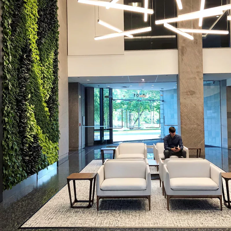 A modern coworking space in an office building with a green wall.